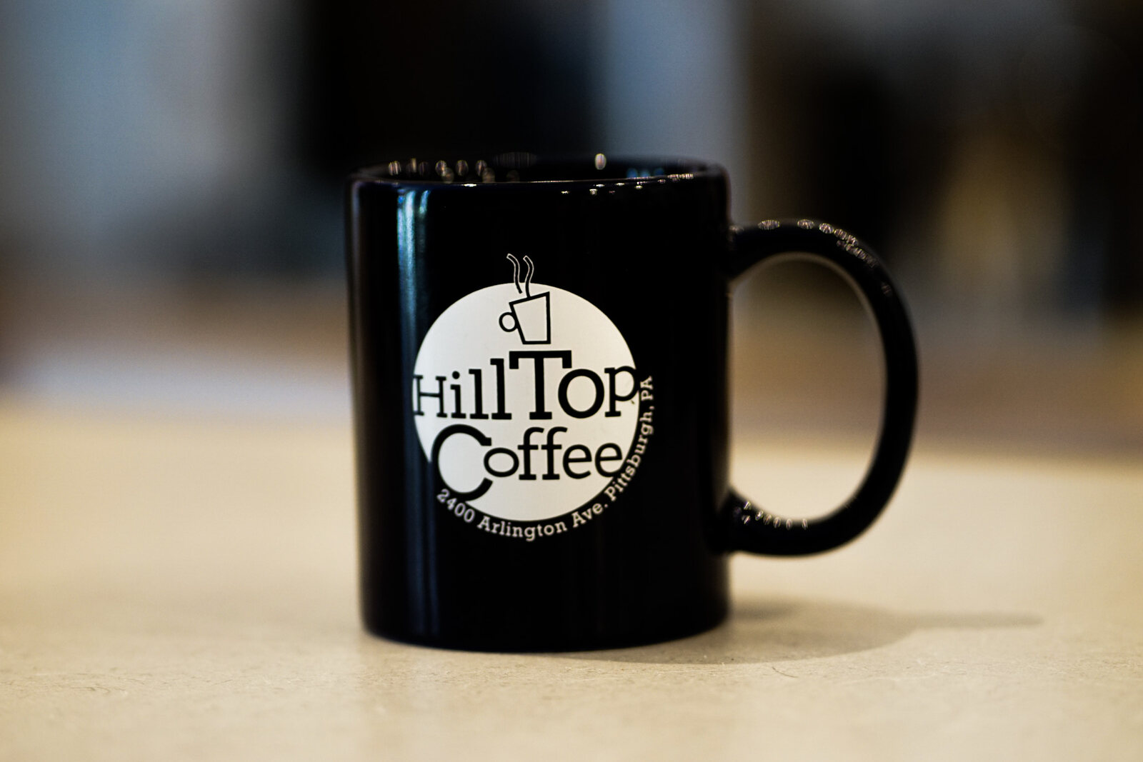 A black Hilltop Coffee mug