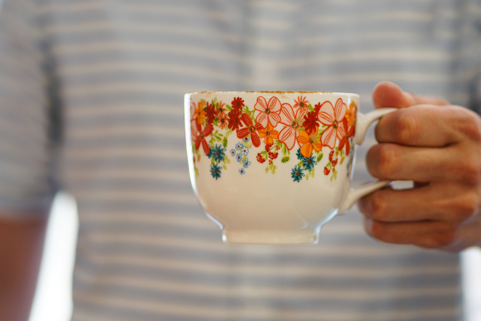 A floral coffee cup held in two hands